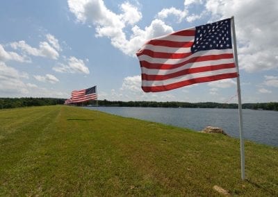 American Flags Blowing in the Wind at the Edge of the Lake